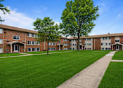 Thumbnail 20 of 23 - A grassy area in front of apartment buildings.