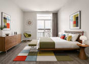 Thumbnail 28 of 58 - A bedroom with a large bed, a chair, and a dresser.