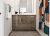Thumbnail 27 of 58 - A bathroom with a brown cabinet and a patterned shower curtain.