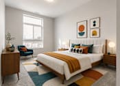 Thumbnail 25 of 58 - A bedroom with a large bed, a chair, and a wooden cabinet.