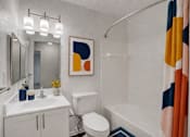 Thumbnail 21 of 39 - A bathroom with a white toilet, a white sink, and a white bathtub.