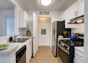 Thumbnail 13 of 39 - A kitchen with black appliances and white cabinets.