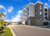 Thumbnail 56 of 58 - A modern apartment building with a clear blue sky above.