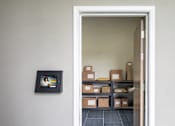 Thumbnail 50 of 58 - A doorway leads to a room with boxes on shelves.