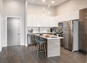 Thumbnail 21 of 58 - A modern kitchen with a center island and stainless steel appliances.