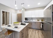 Thumbnail 3 of 58 - A modern kitchen with a white countertop and stainless steel appliances.