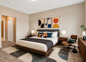 Thumbnail 15 of 58 - A bedroom with a bed, chair, and a painting on the wall.