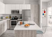 Thumbnail 10 of 64 - A modern kitchen with a large island and a dining area.