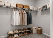 Thumbnail 28 of 64 - A closet with clothes and shoes neatly organized on shelves and racks.