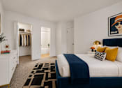 Thumbnail 12 of 87 - A bedroom with a large bed and a painting of a woman wearing a hat.