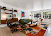 Thumbnail 6 of 87 - A living room with a green couch, a coffee table, and a rug.