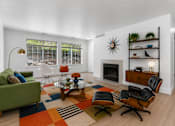 Thumbnail 5 of 87 - A living room with a green couch, a coffee table, and a fireplace.
