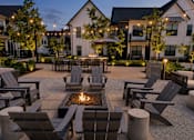 Thumbnail 30 of 39 - A fire pit is surrounded by chairs in a courtyard.