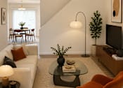 Thumbnail 5 of 20 - A living room with a white couch, a black coffee table, and a television.
