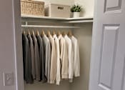 Thumbnail 11 of 20 - Clothes hanging on a rack in a room.