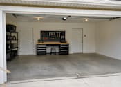 Thumbnail 20 of 20 - A garage with a workbench and storage drawers.