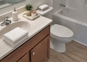 Thumbnail 18 of 20 - A bathroom with a white toilet, a sink, and a shower.