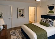 Thumbnail 17 of 20 - A bedroom with a bed, a lamp, and a framed picture on the wall.