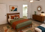 Thumbnail 7 of 20 - A bedroom with a bed, dresser, and mirror.