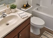 Thumbnail 8 of 20 - A white toilet sits next to a sink in a bathroom.