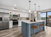 Thumbnail 18 of 58 - A modern kitchen with a blue island and stainless steel appliances.