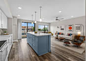 Thumbnail 19 of 58 - A modern kitchen with a large island and a view of the outdoors.