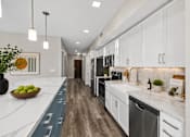 Thumbnail 17 of 58 - A modern kitchen with white cabinets and a wooden floor.