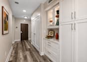 Thumbnail 14 of 58 - A hallway with a brown floor and white walls.