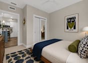Thumbnail 28 of 58 - A bedroom with a bed, a dresser, and a framed picture on the wall.