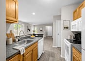 Thumbnail 53 of 87 - Modern kitchen with granite countertops and oak cabinets at Village Club of Farmington Hills Apartments, Farmington Hills, MI 48331