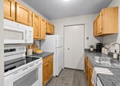Thumbnail 51 of 87 - Kitchen with white appliances and oak cabinetry at Village Club of Farmington Hills Apartments, Farmington Hills, MI
