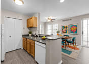 Thumbnail 52 of 87 - Open concept kitchen with breakfast bar and dining area at Village Club of Farmington Hills Apartments, Farmington Hills