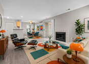 Thumbnail 61 of 87 - A living room with a fireplace and a chairs at Village Club of Farmington Hills Apartments, Farmington Hills, MI