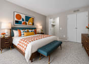 Thumbnail 77 of 87 - Contemporary bedroom with colorful artwork and teal bench at Village Club of Farmington Hills Apartments, Farmington Hills, 48331