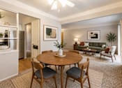 Thumbnail 10 of 26 - A dining room with a table and chairs.
