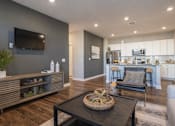Thumbnail 4 of 39 - A modern living room with a wooden floor and a grey wall.