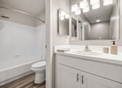 Thumbnail 37 of 87 - Bathroom with white cabinetry and tub shower combo at Village Club of Farmington Hills Apartments, Farmington Hills
