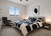 Thumbnail 16 of 33 - A bedroom with a bed, chair, and a ceiling fan.