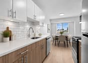 Thumbnail 3 of 33 - A modern kitchen with wooden cabinets and a dining table.
