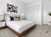 Thumbnail 14 of 33 - A bedroom with a white bed and a black and white abstract painting above it.