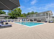 Thumbnail 20 of 33 - A large outdoor swimming pool with a sun lounger and umbrella.