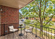 Thumbnail 24 of 29 - A balcony with a table and two chairs.