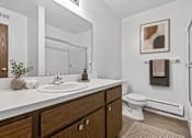 Thumbnail 6 of 29 - A bathroom with a white countertop and a white toilet.