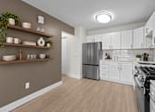 Thumbnail 3 of 18 - A kitchen with white cabinets and a refrigerator.