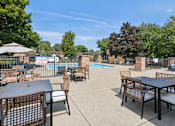 Thumbnail 30 of 38 - A pool area with tables and chairs and a sign that says "WARNING".