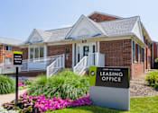 Thumbnail 43 of 45 - a leasing office sign in front of a brick building