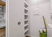 Thumbnail 25 of 87 - Laundry room with builtin storage shelves and utility sink at Village Club of Farmington Hills Apartments, Farmington Hills, 48331