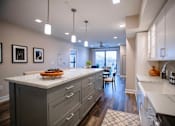Thumbnail 5 of 31 - a large kitchen with white counter tops and a dining area