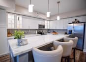 Thumbnail 2 of 31 - a large kitchen with white cabinets and white counter tops