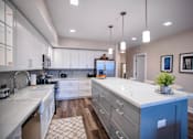 Thumbnail 4 of 31 - a large kitchen with white cabinets and white counter tops